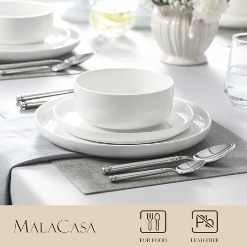 Elegant white dinnerware set with plates and bowl on a table.