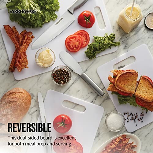 Reversible cutting board with knife, sandwiches, tomatoes, and condiments.