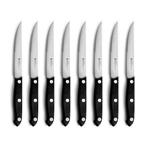 Set of seven serrated steak knives with black handles.